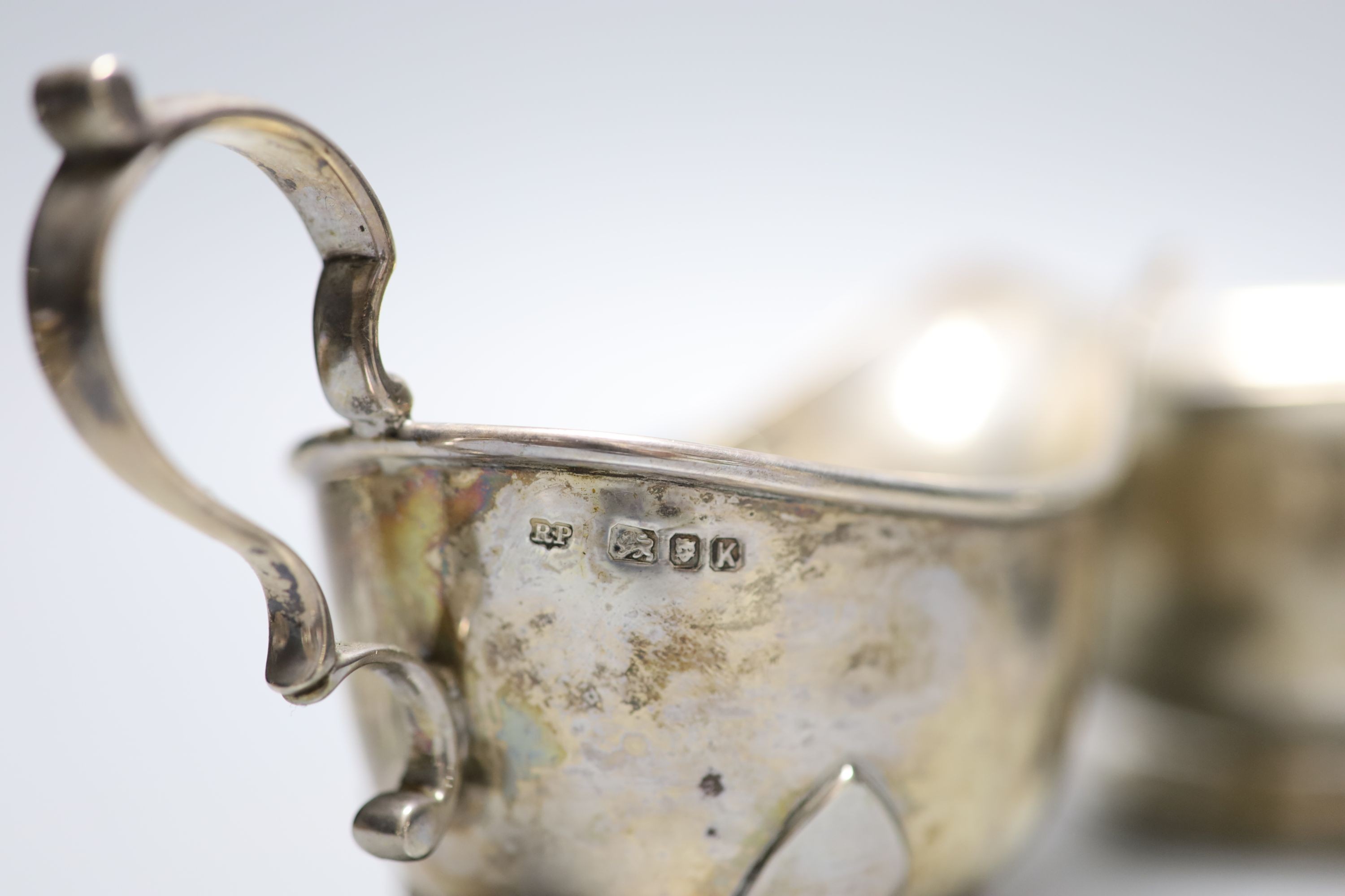 Two George V silver sauceboats and a similar silver two handled sugar bowl, with engraved inscription, 15.5oz.